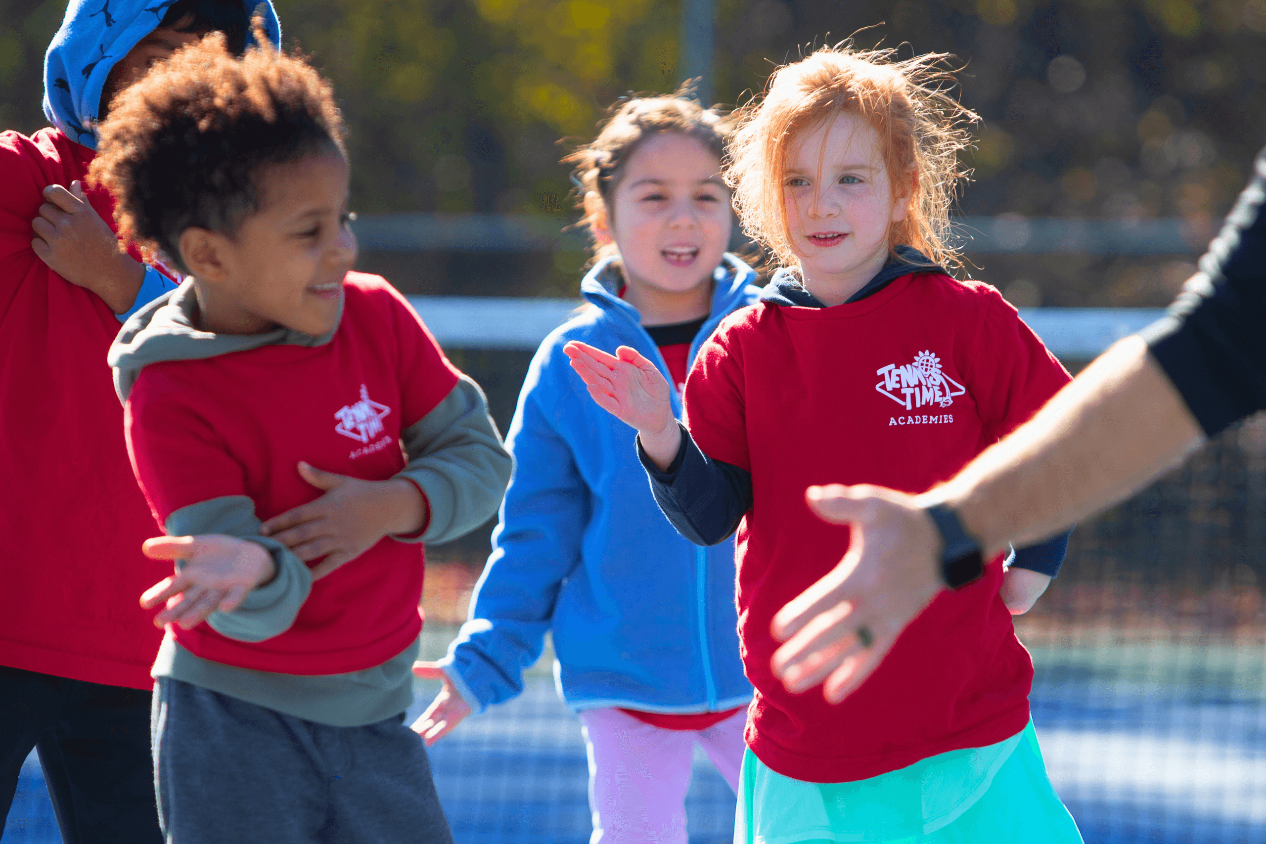 Kids enjoying tennis activities in a group setting at Tennis Time Academies, a program designed for players 10 and under to learn and have fun