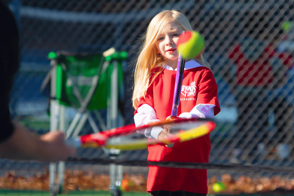 A young child learning tennis fundamentals during a Tennis Time Academies class, perfect for kids aged 3-10 as an engaging extracurricular activity or PE alternative.