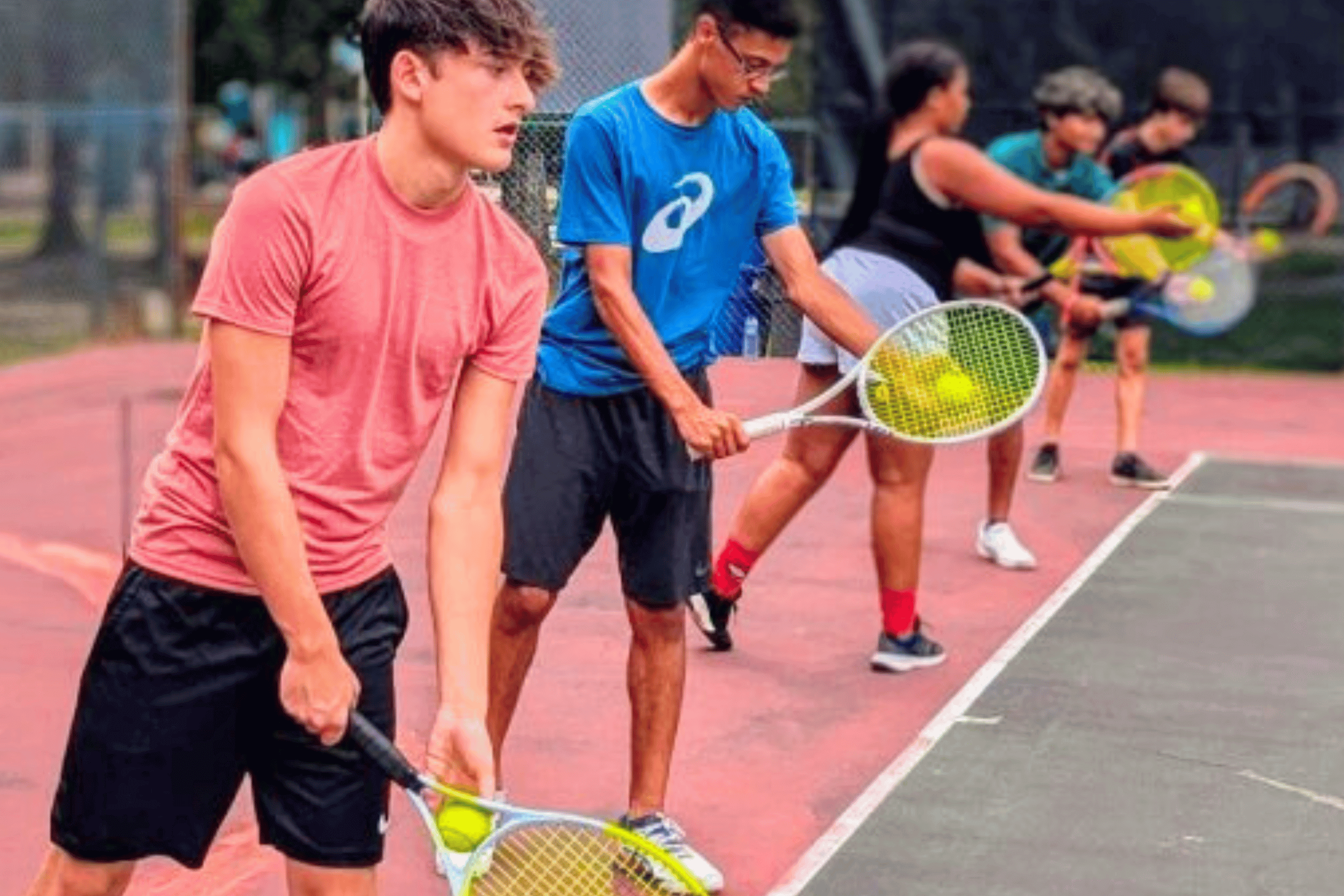 Middle and high school students participating in tennis lessons, focusing on skill development and teamwork at Tennis Time Academies