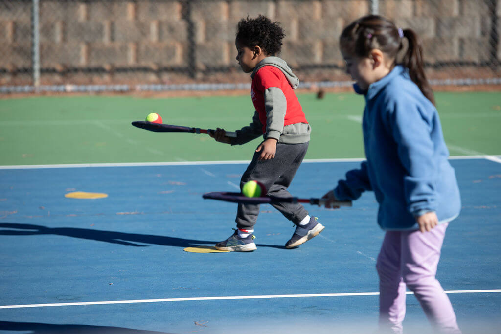 Young child improving coordination and balance while playing tennis with a SMART Racket