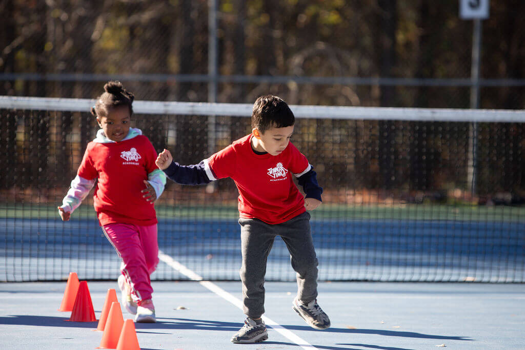 Child developing coordination and motor skills through tennis drills
