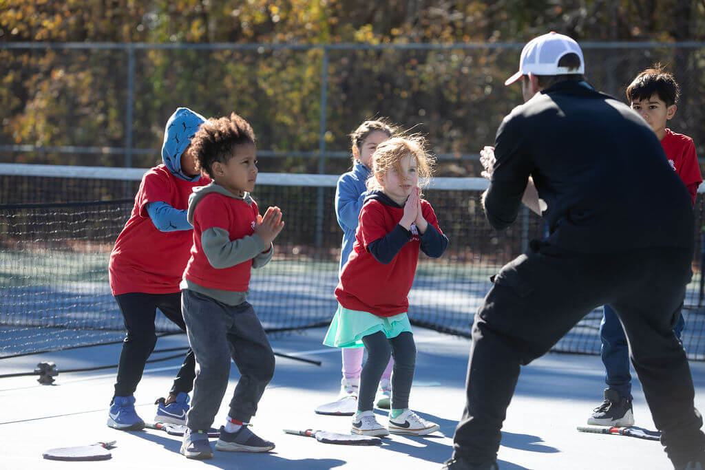 Young child practicing tennis while learning focus and discipline through SMART Tennis drills.