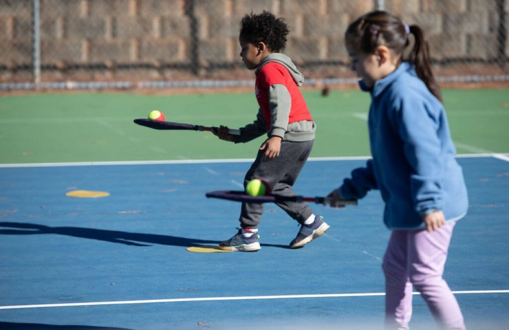 Young child improving coordination and balance while playing tennis with a SMART Racket