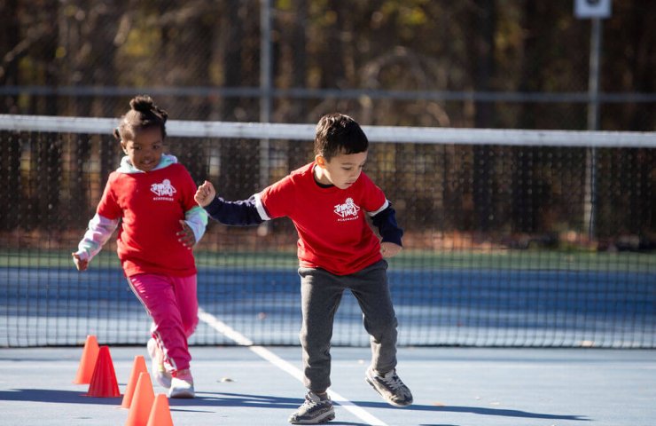 Child developing coordination and motor skills through tennis drills