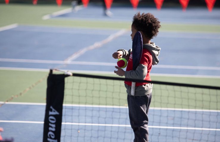 a young child holding smart racket