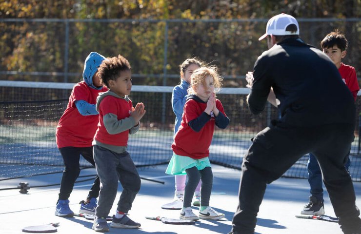 Young child practicing tennis while learning focus and discipline through SMART Tennis drills.